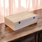 Wooden deck box on a wooden surface with a soft pink curtain in the background