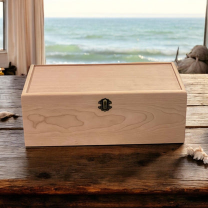 Closed wooden memory box with a front latch on a wooden table with an ocean view
