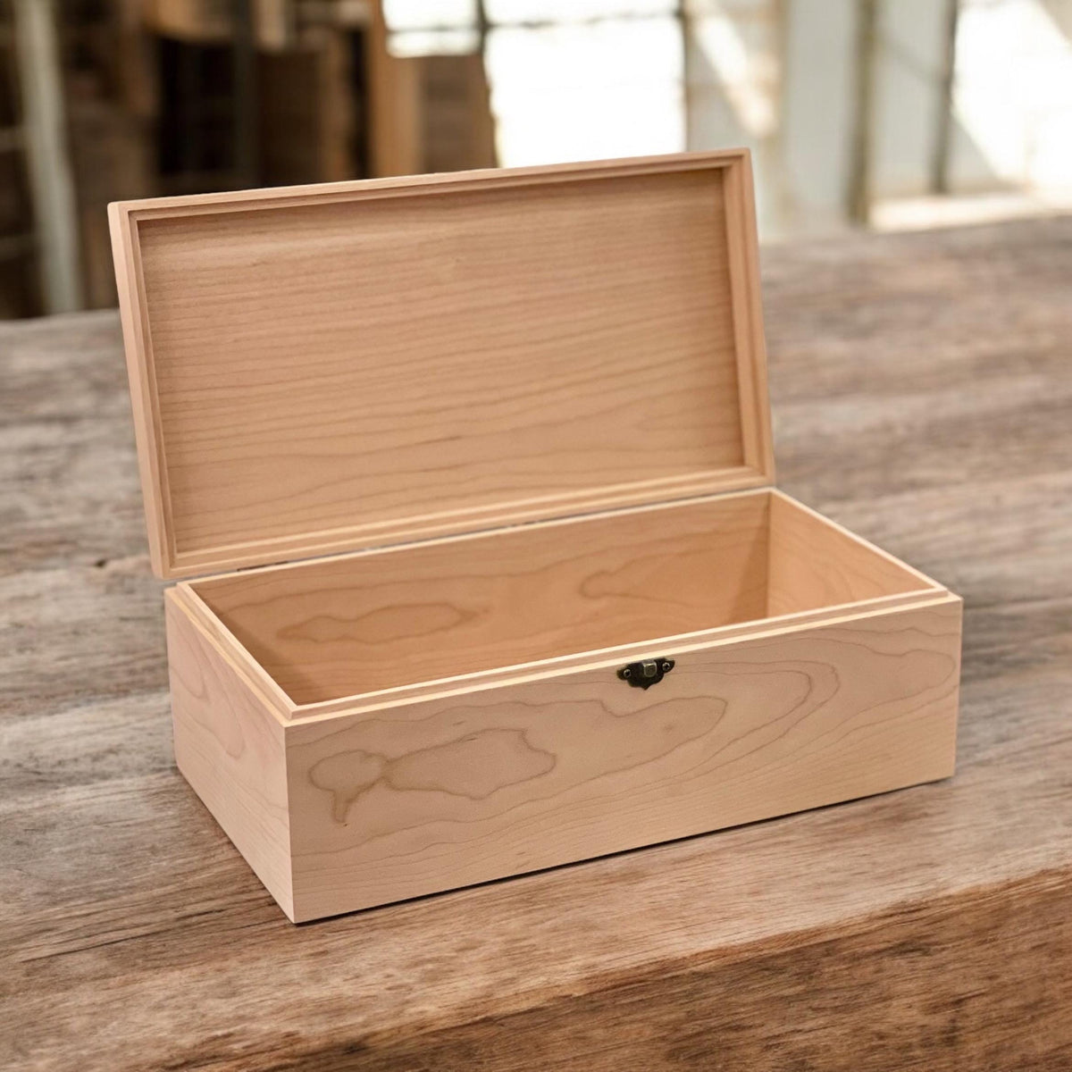 Open handmade wooden box with hinged lid and empty interior in soft light